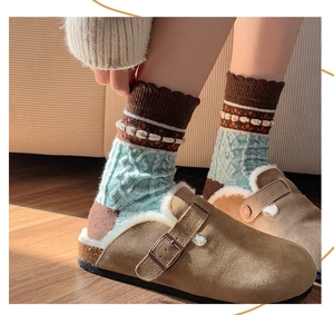 Close-up of brown suede clogs with plush faux shearling lining and vintage knit socks