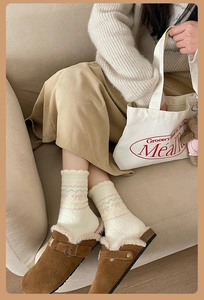 Close-up of warm plush socks with embroidery and brown suede mule shoes with fur lining