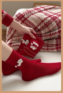 Détail de chaussettes rouges en coton avec broderie ours et boutons en perles décoratifs