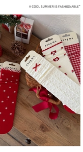 Detailed view of red floral and cat pattern socks in a festive Christmas gift basket