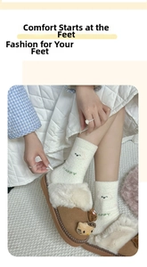 Close-up of brown plush cat slippers with warm cream-colored knitted winter socks