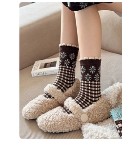 Detail of wool socks with floral pattern paired with plush Mary Jane slippers for winter