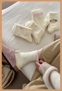 Detail of plush thermal socks featuring ruffled cuffs and cute puppy embroidery patterns
