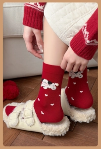Détail de chaussettes rouges avec coeurs blancs, chien de dessin animé et perle