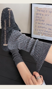 Detail of grey wool flecked knit socks showing texture and elasticity with grey felt shoes
