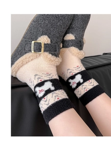 Nahaufnahme von Fair-Isle-Stricksocken mit Hundemotiv und fleecegefütterten Hausschuhen