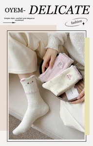 Detail of warm fluffy coral fleece socks with cute cat embroidery and 3D ear design