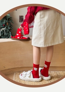 Detailed view of red Christmas crew socks featuring white cartoon bear and heart patterns