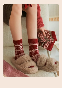 Close-up of red Fair Isle socks with white snowflake patterns and thick winter texture