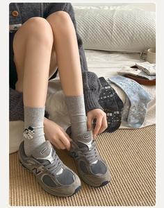 Details von grauen Baumwollsocken mit Stickerei und modischen Retro-Sneakern
