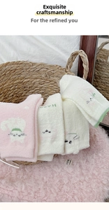 Detail of soft coral fleece cat socks with cute embroidery on a pink plush background