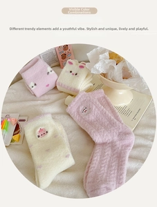 Detail view of thick winter socks with cute cartoon cat and bunny embroidery on soft fabric