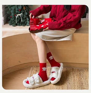 Detail of red festive socks with cute bear embroidery and heart patterns for winter