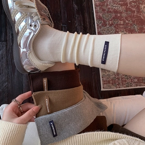 Neutral ribbed long socks with sustainable leather patches in cream, brown, and grey colors