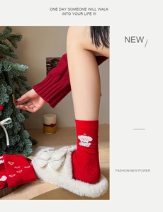 Detail of red crew socks featuring a white 3D embroidered puppy and soft knit texture