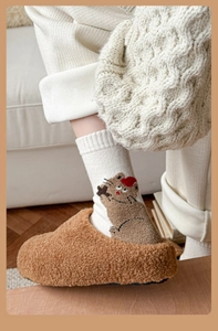 Detail of cute animal pattern knit sock and plush sherpa slipper for winter warmth