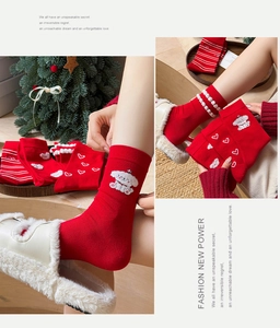 Detail of red crew socks featuring white cartoon puppy embroidery and heart patterns