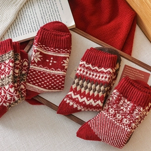 Cozy red Fair Isle wool socks in a warm home setting with books and a blanket