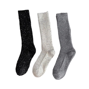 Three pairs of warm wool blend crew socks in black beige and grey with flecked patterns