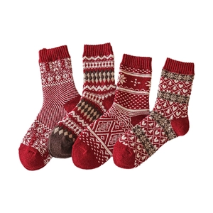 Set of four red thick wool socks with Nordic snowflake and diamond patterns for winter