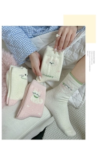 Close-up of cozy coral fleece socks with cute cat embroidery and soft plush texture