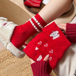 Festive red crew socks with cute cartoon dog embroidery and white pom-pom trim details