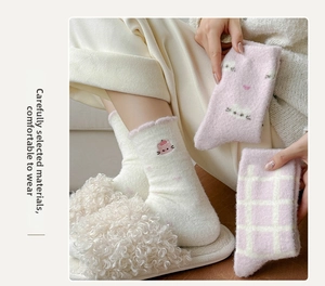 Close-up of thick thermal coral fleece socks with cute cat embroidery and pink plaid pattern