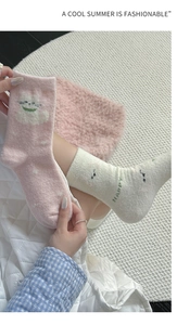 Detail of plush cat socks featuring happy text and soft thermal coral fleece texture