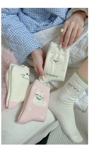 Detail of warm fluffy mid-calf socks with cute cat embroidery and HAPPY text