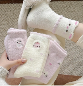 Close-up of thick winter plush socks with cute cat embroidery and soft wavy cuffs