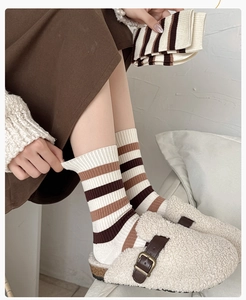 Vue de dessus de chaussettes en tricot à rayures café avec sabots en peluche pour un look cosy
