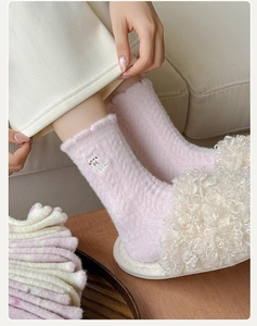 Detail of pink coral fleece thermal socks with cute cat embroidery for winter warmth