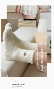 Détail de chaussettes blanches en polaire de vison avec broderie ours dessin animé