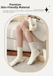 Gros plan de chaussettes thermiques en peluche blanche avec broderie animale douce