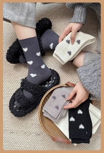Détail de motifs en cœur sur des chaussettes en maille épaisses grises et noires