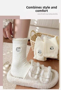 Détail de chaussettes blanches pelucheuses avec broderie animale et texture chaude