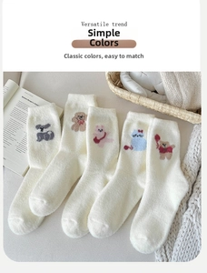 Gros plan de cinq paires de chaussettes thermiques blanc cassé avec broderies d'animaux