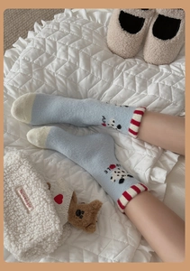 Detailed view of plush light blue thermal socks with cartoon bear and striped cuff detail