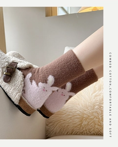 Detail of tan combed cotton mid-tube socks with pink rabbit pattern and soft texture