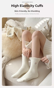 Gros plan sur la broderie animale de chaussettes épaisses en polaire corail blanc cassé