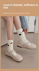 Detail of warm white fleece socks featuring a cute cartoon dog motif and soft Mary Jane shoes