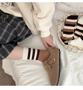 Détail de chaussettes rayées d'automne avec mocassins marron en décor intérieur