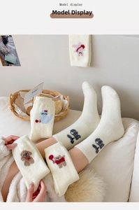 Détail de la broderie animale sur d'épaisses chaussettes thermiques douces blanc cassé