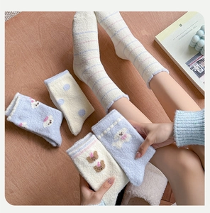 Detailed view of warm coral fleece socks featuring cute bear embroidery and striped patterns