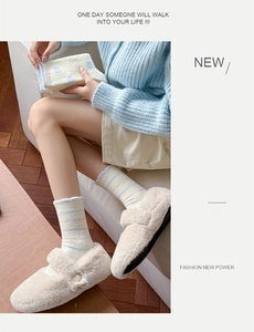 Close-up of beige plush slippers with large buttons and striped knit thermal socks