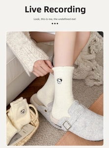 Détail de la broderie chiot sur des chaussettes thermiques épaisses en polaire crème