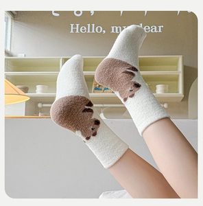Detail of soft white thermal winter socks with cartoon bear pattern and brown accents