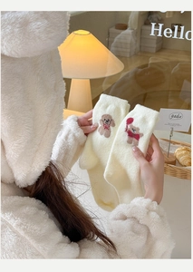 Gros plan de chaussettes en polaire crème avec broderie d'ours mignonne et texture douce