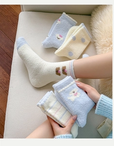 Detail of warm thickened coral fleece socks with cute dog patterns and polka dots