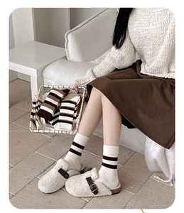 Détail de chaussettes à rayures marron et blanc avec des chaussons en polaire doux